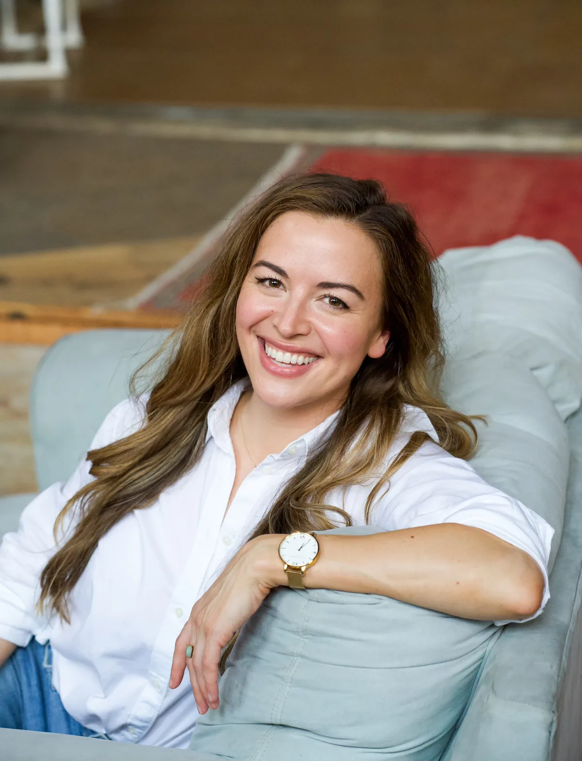 Jessica smiling on a sofa