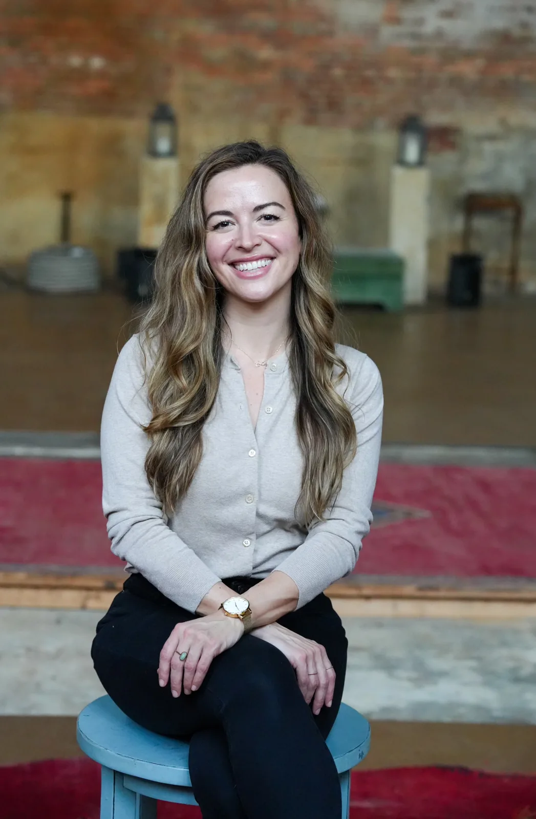 Jessica seated on a stool, smiling at the camera