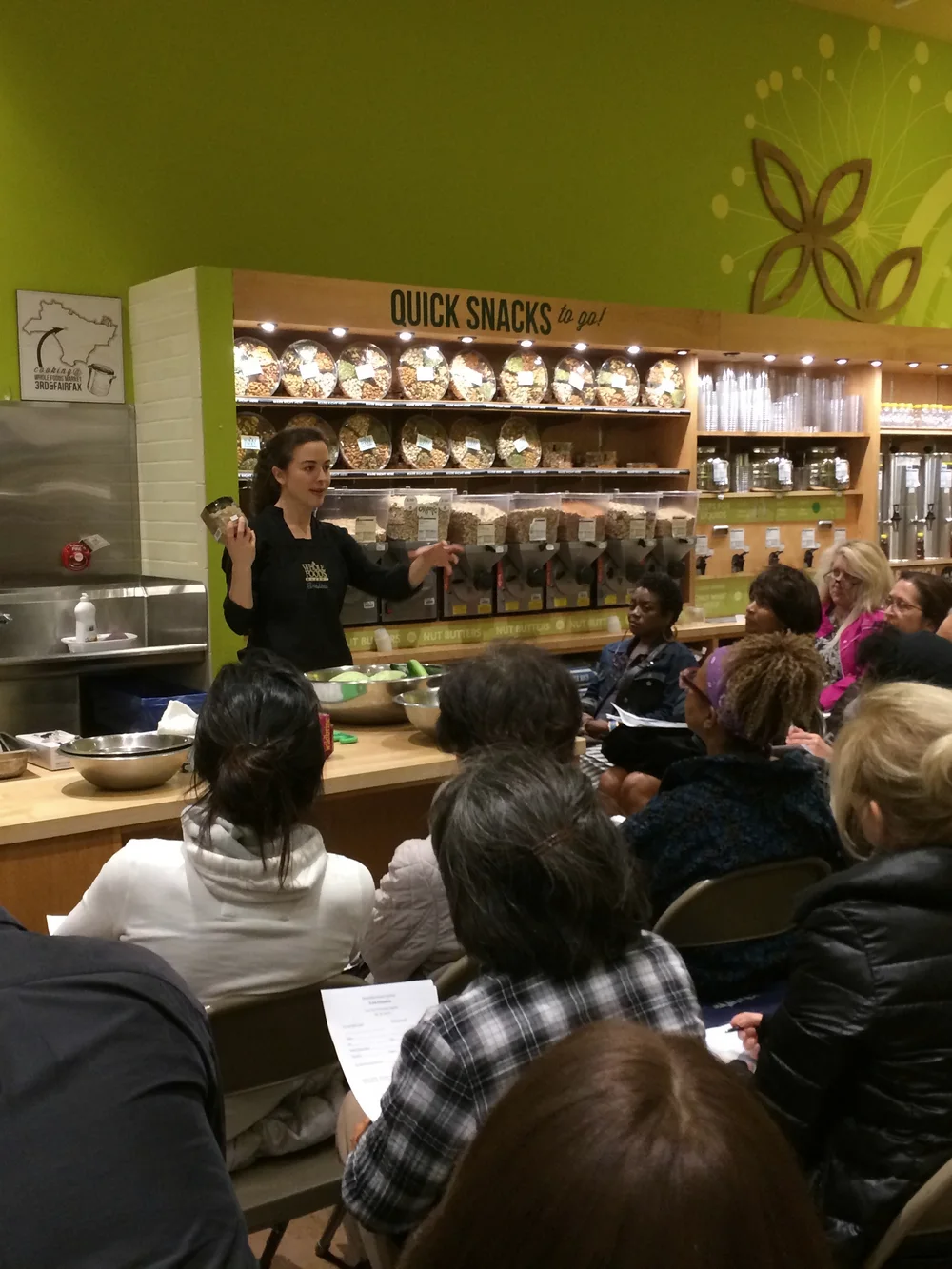 Jessica teaching a cooking class to a full room at Whole Foods