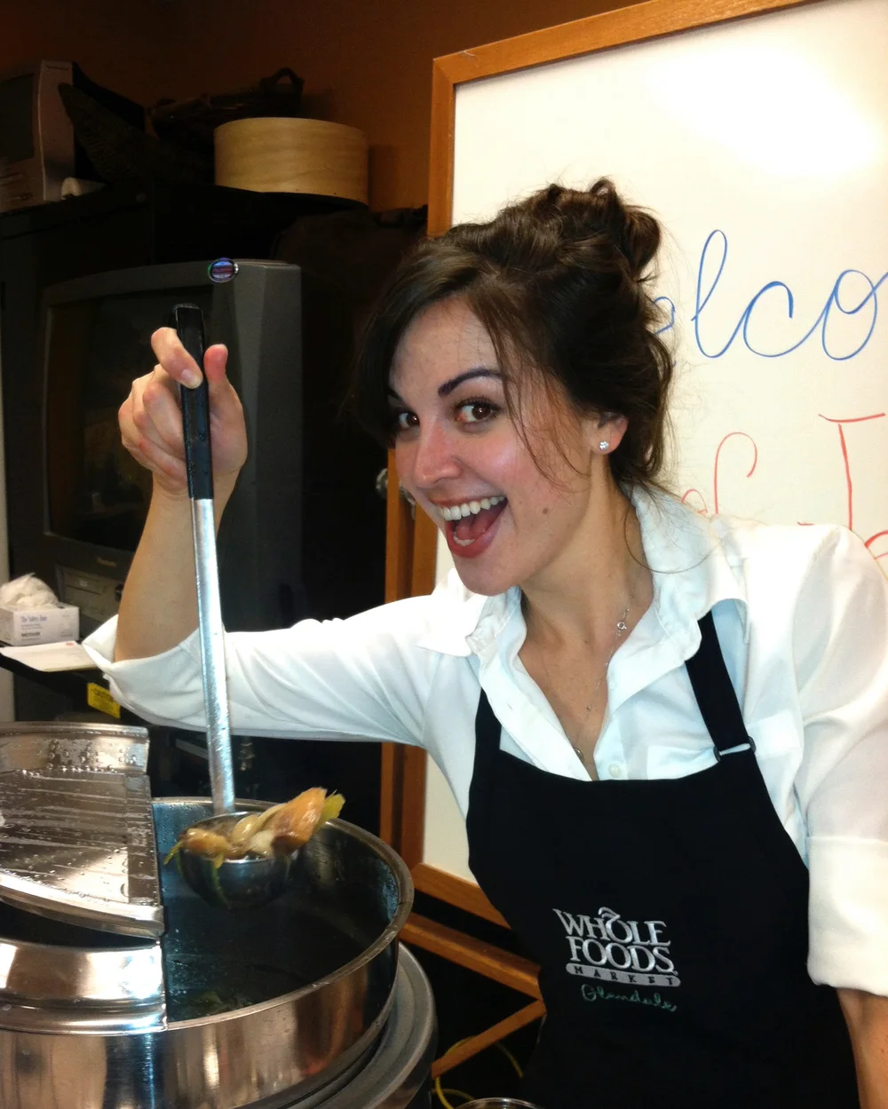 Jessica grinning with a ladle at a cooking demo
